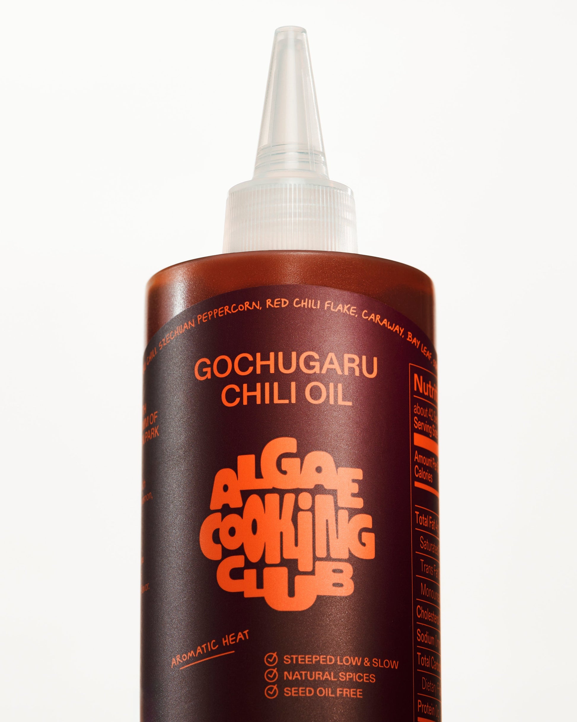 Algae Cooking Club Chef Squeeze Trio oil bottles with colorful labels, arranged on a wooden surface.