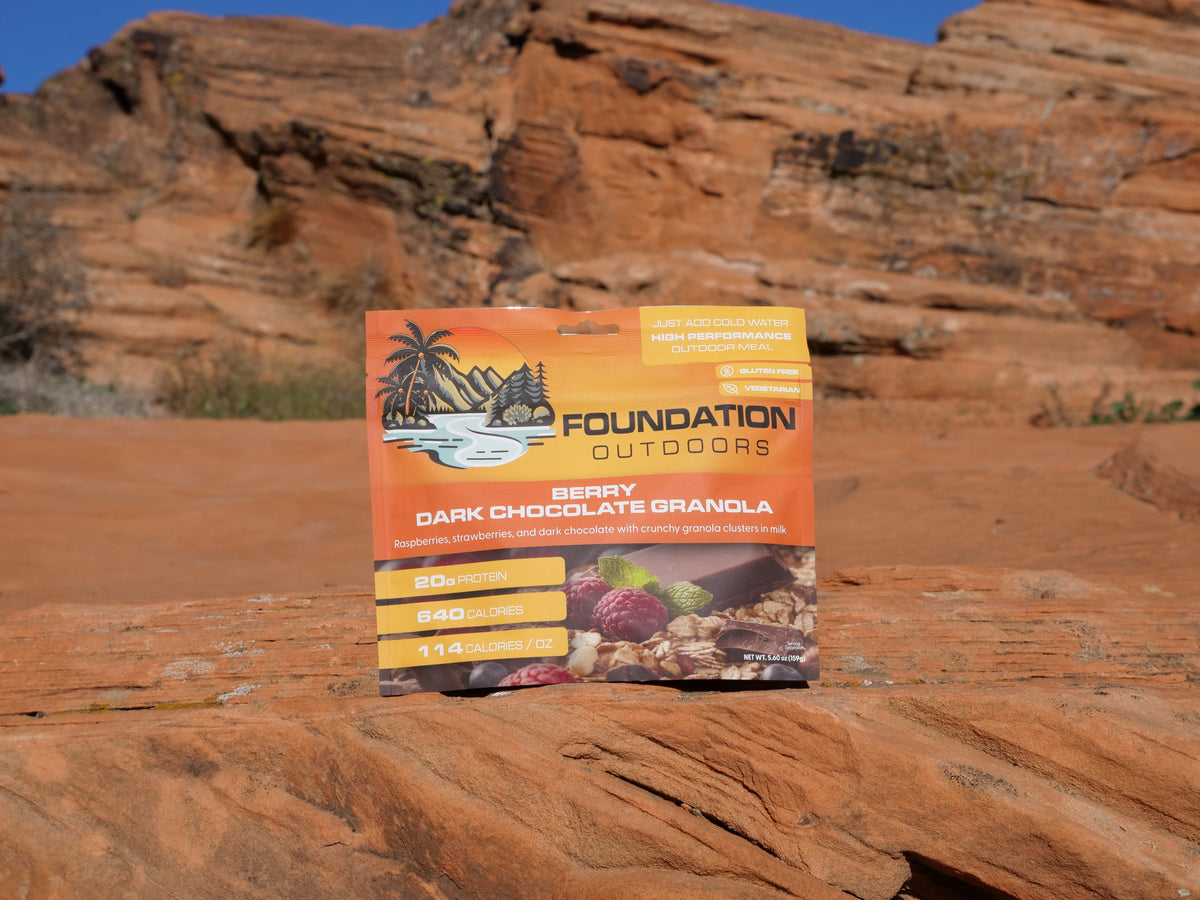 Bag of FOUNDATION Outdoors Berry Dark Chocolate Granola with visible berries and chocolate chunks on the packaging.