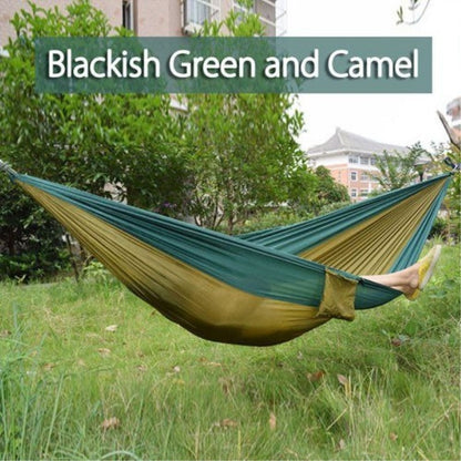 Portable nylon parachute backpacking double hammock for outdoor camping, shown suspended between trees