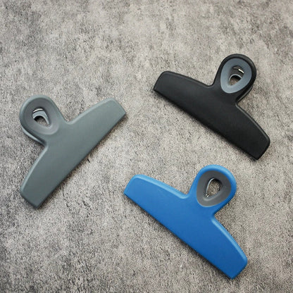 Blue Dura Living 4-piece bag clip set for sealing food bags in kitchen, durable plastic clips with metal springs.