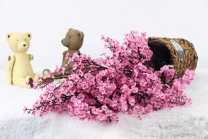 Artificial flower with delicate petals and green leaves in a realistic decorative arrangement