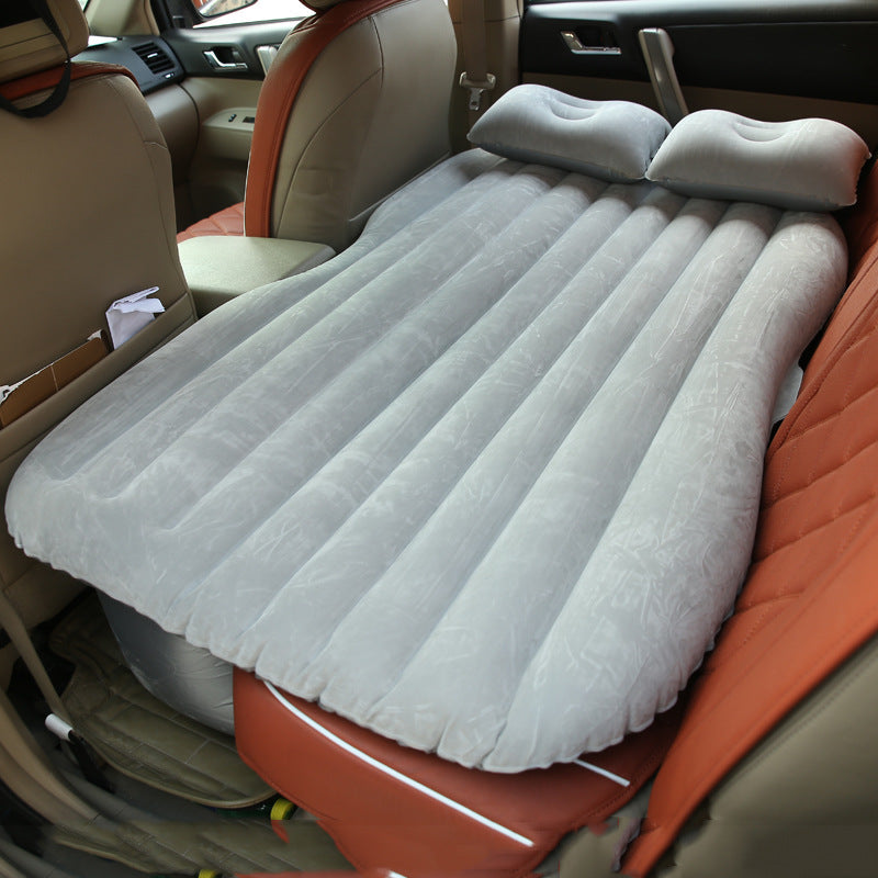 Inflatable car bed with cushioned surface and raised sides for comfortable travel sleeping setup