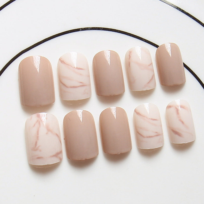 Light khaki smudge false nails in a neutral abstract design