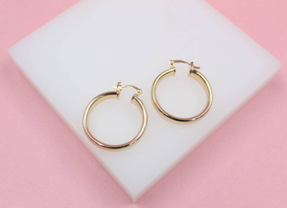 18K gold filled 6mm thin lever back hoop earrings by MIA Jewelry, showing the sleek, lightweight gold hoops with clasp closure.