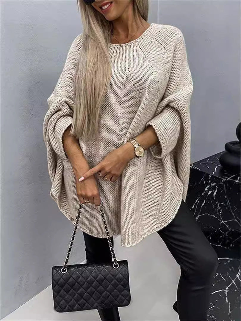 Women's oversized knitted pullover sweater with loose batwing sleeves and shawl-style neckline in winter fashion.