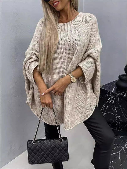 Women's oversized knitted pullover sweater with loose batwing sleeves and shawl-style neckline in winter fashion.