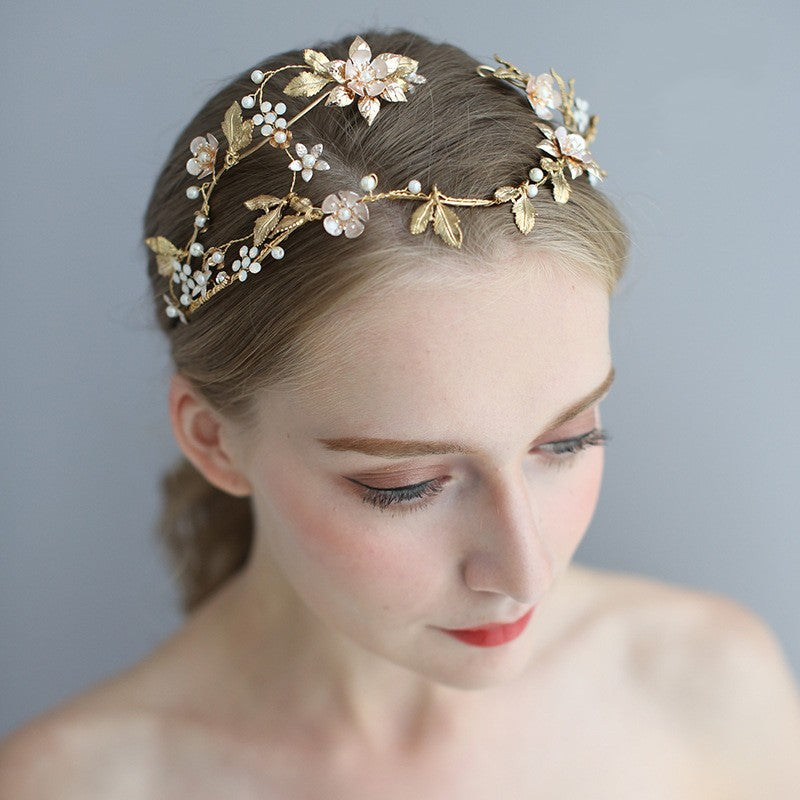 Shaped asymmetric handmade bridal head jewelry with intricate detailing, displayed on a neutral background