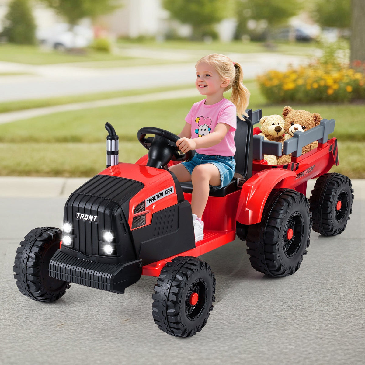Kids riding a 24V electric ride-on tractor with a detachable trailer and remote control, designed for outdoor play.