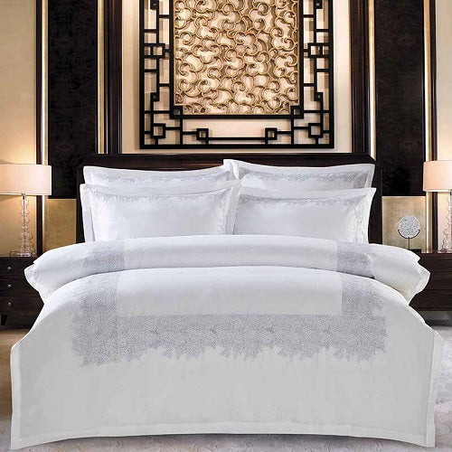 Four-piece cotton bedding set in a coordinated design, shown as a complete set with duvet cover and pillowcases