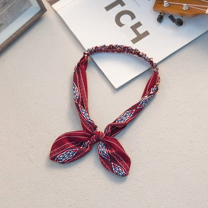 Big bow tie bunny ears headband with playful rabbit ears in a close-up product view