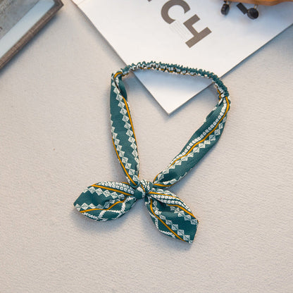 Big bow tie bunny ears headband in a playful design񎟟