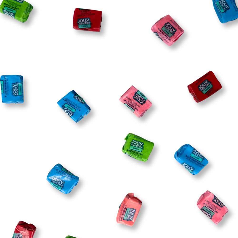 Colorful Jolly Rancher Fruit Chews candy in assorted flavors, displayed in a clear bowl on a white background.