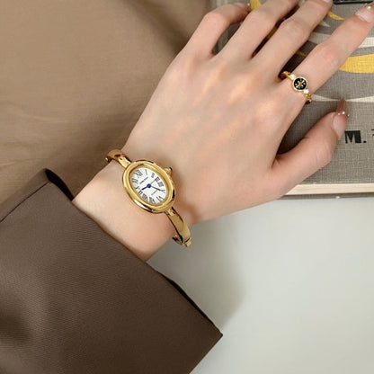 Women's oval Roman-numeral bracelet watch with a classic metal band and analog dial