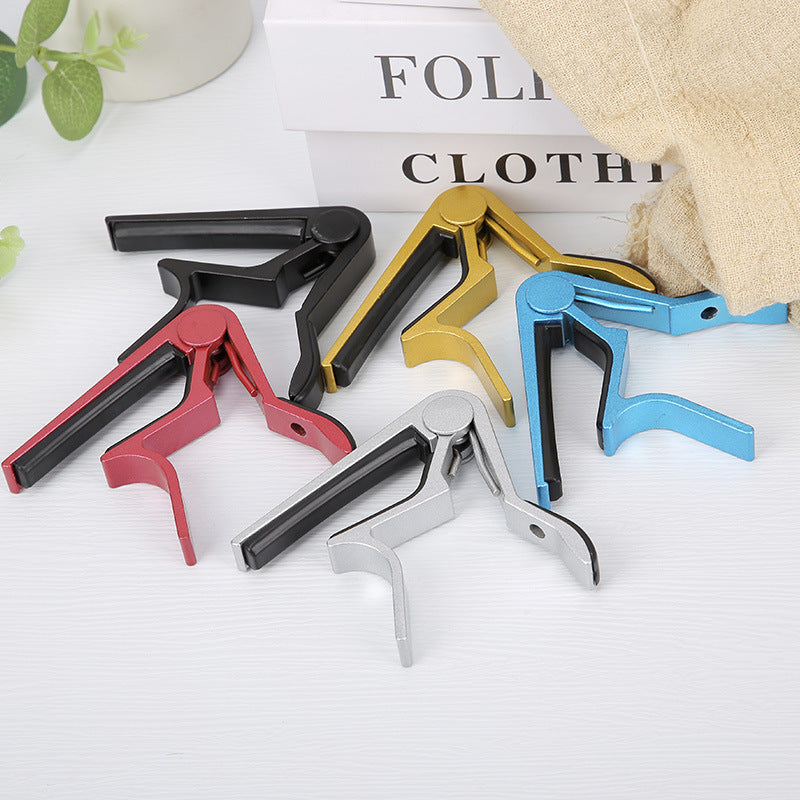 Portable metal guitar capo tuning clip for home use, shown in compact design