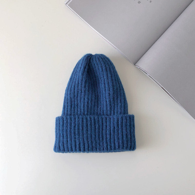 Warm knitted hat in a cozy textured design, photographed on a plain background