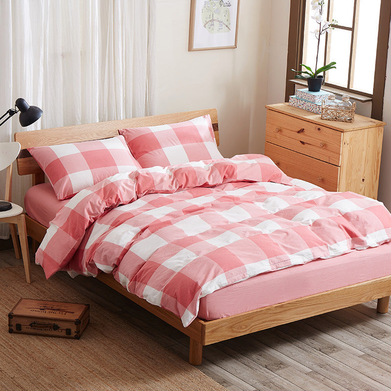 Pure cotton four-piece bed sheet set in a soft, breathable fabric, neatly arranged for a bedroom bed