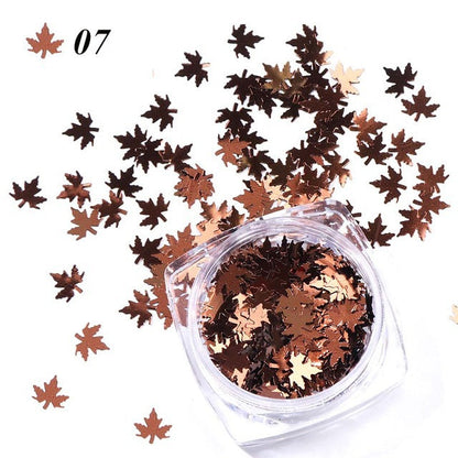 Gradient maple leaf nail sequins in autumn colors for nail art close-up