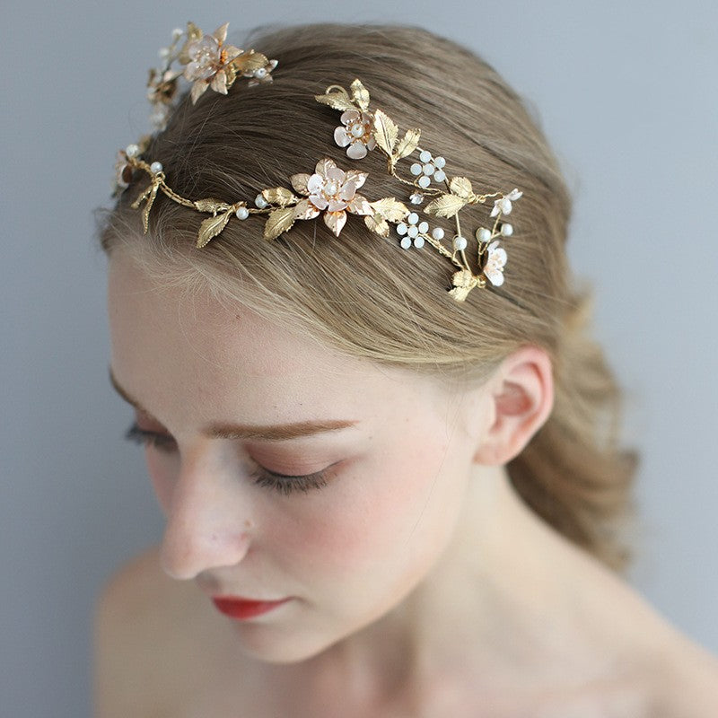 Asymmetric handmade bridal head jewelry with a sculpted shape on a white background