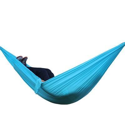 Portable nylon parachute double backpacking hammock for outdoor use, shown suspended between trees