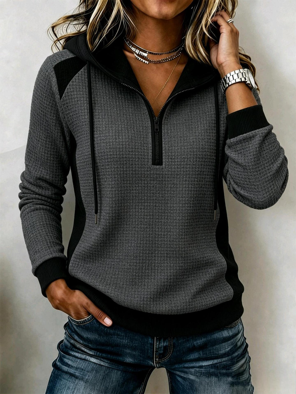 Women's waffle-knit half-zip hooded sweatshirt in textured fabric with drawstring hood and front zipper.