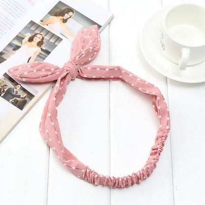 Big bow tie bunny ears headband displayed against a plain background