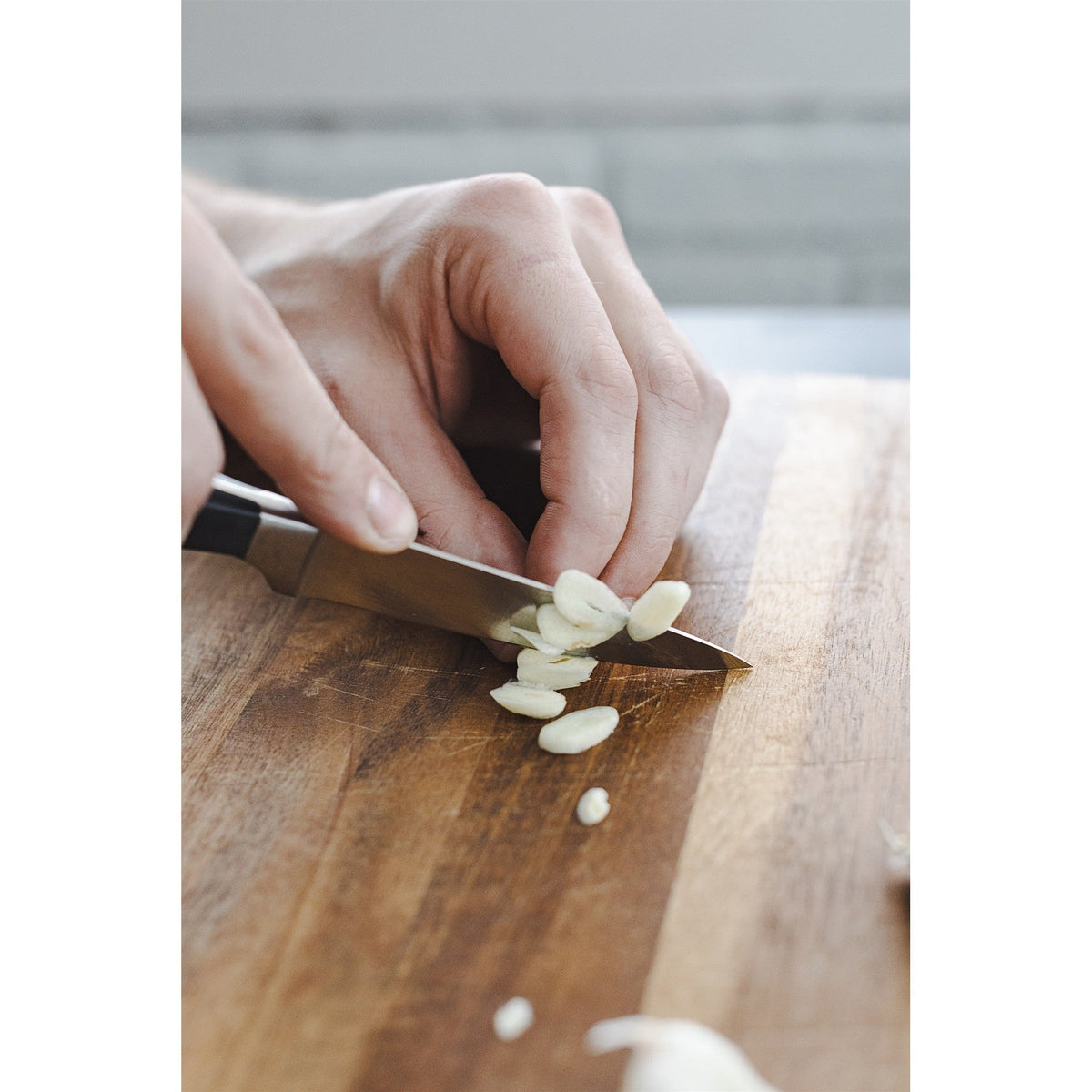 Dura Living Superior 3.5 inch black paring knife with a sleek handle and sharp blade for precise kitchen peeling and slicing.