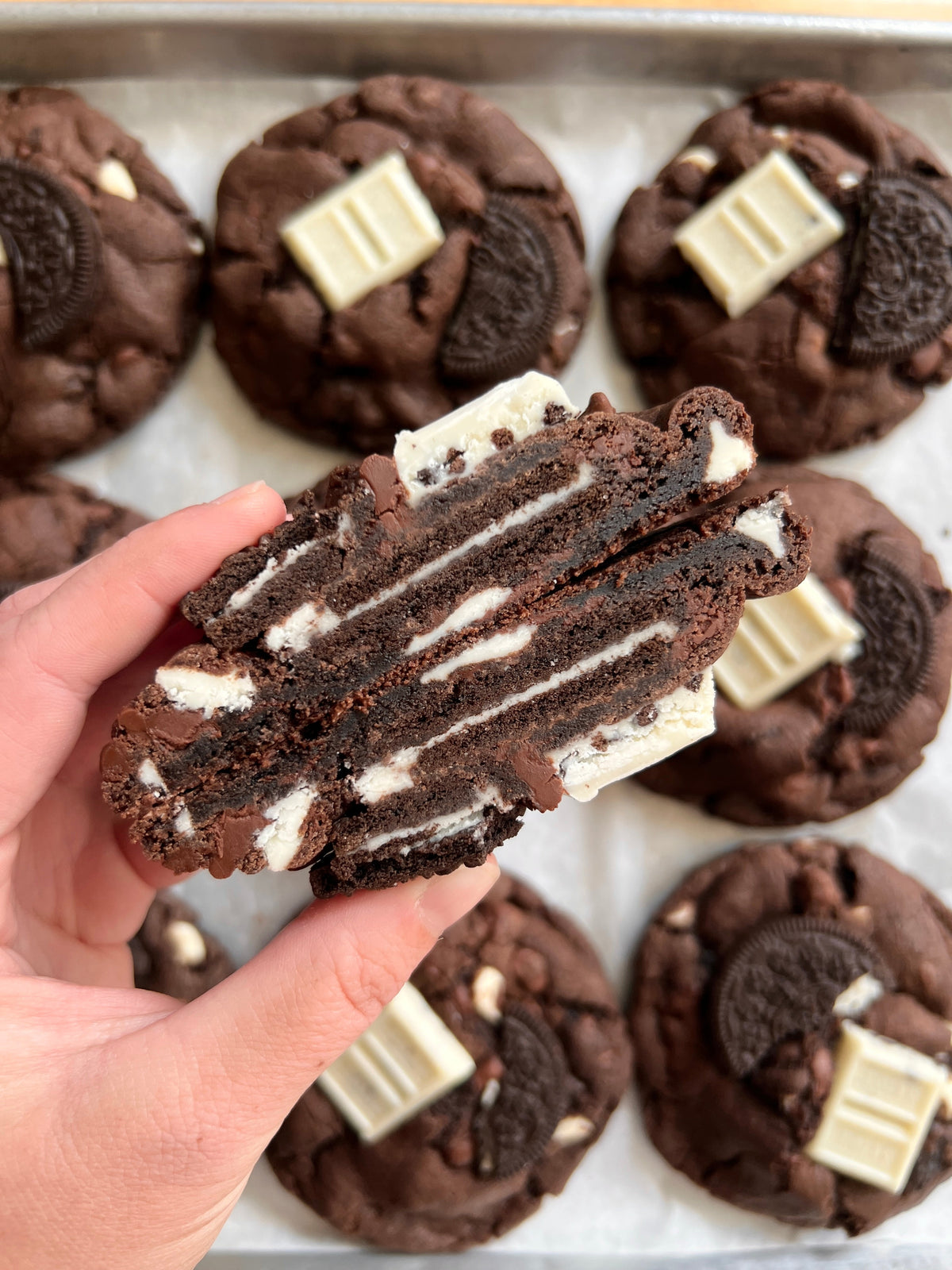 Chocolate Cookies & Cream cookies from Let's Get Baked Artisan Desserts, showing a stack of crispy, chocolate-filled cookies with cream filling.