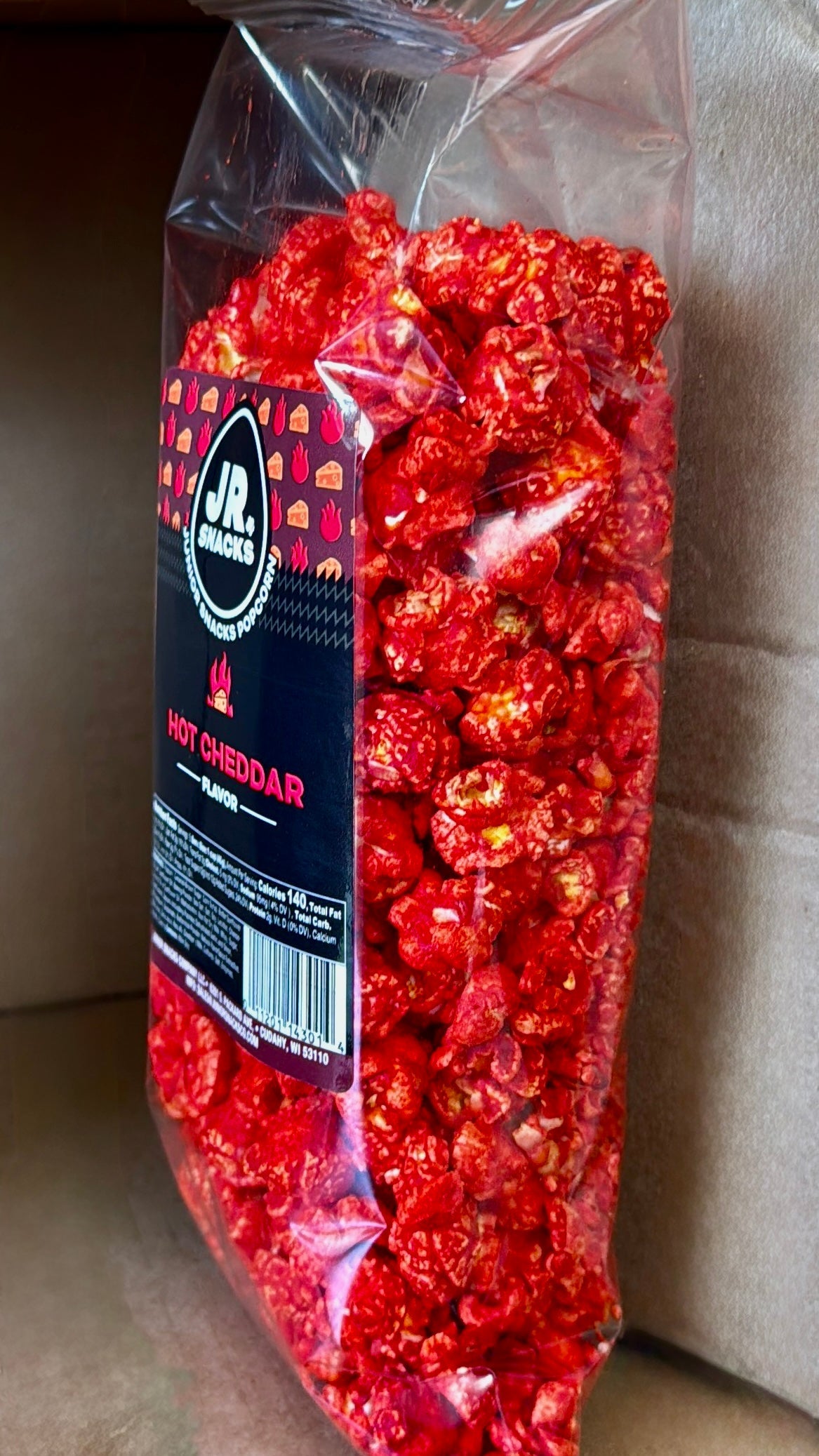 Junior Snacks Co. Hot Cheddar snack bag featuring colorful packaging and crispy cheddar-flavored snacks.