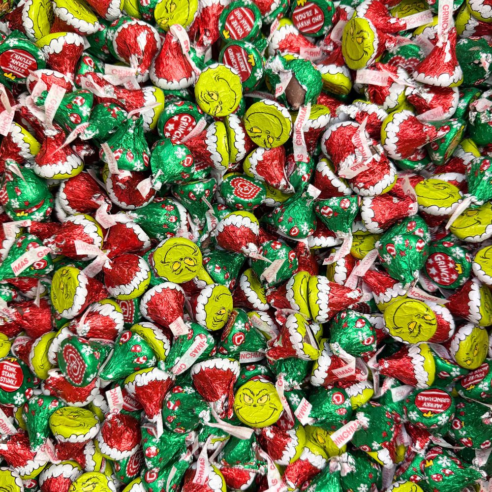 Hershey's Kisses Milk Chocolate Grinch candies in a bulk value bag, featuring festive green and red packaging with the Grinch design.