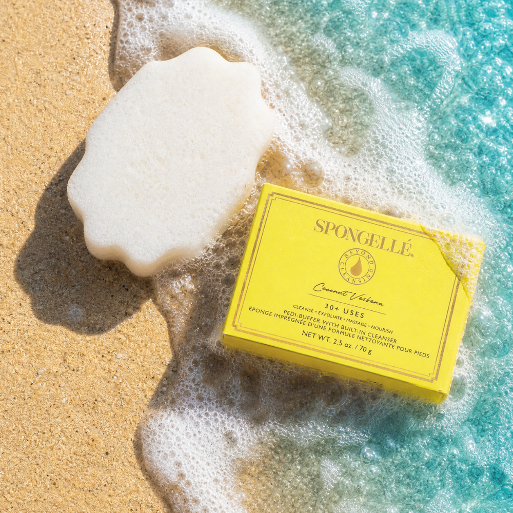 Spongellé Coconut Verbena Pedi Buffer showing a textured, lavender-colored buffer pad for foot exfoliation and care.