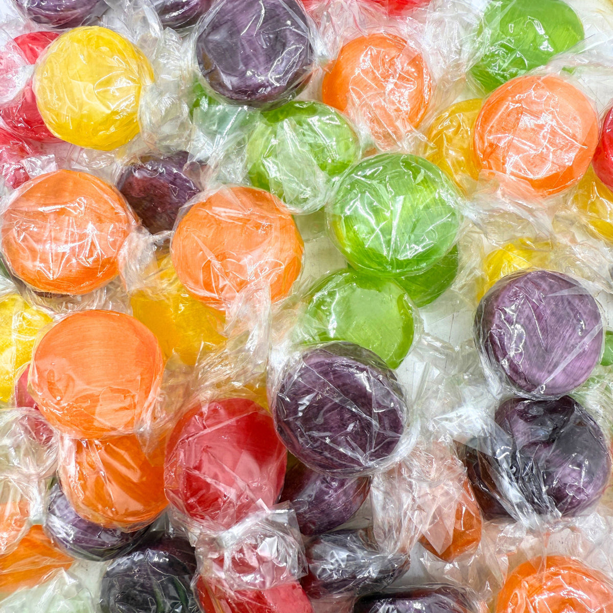 Assorted fruit flavored hard candies from Candy In Bulk in a bulk value bag, colorful and shaped like small fruit buttons.