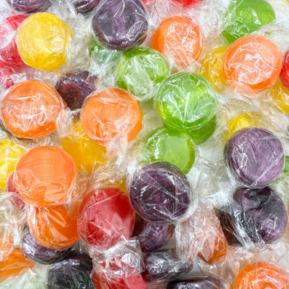 Assorted fruit flavored hard candies from Candy In Bulk in a bulk value bag, colorful and shaped like small fruit buttons.