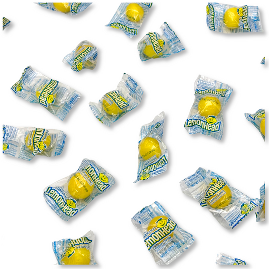 Bulk Lemonhead Original Lemon Hard Candy from Candy In Bulk, showing bright yellow, round lemon-flavored candies in a clear bag.