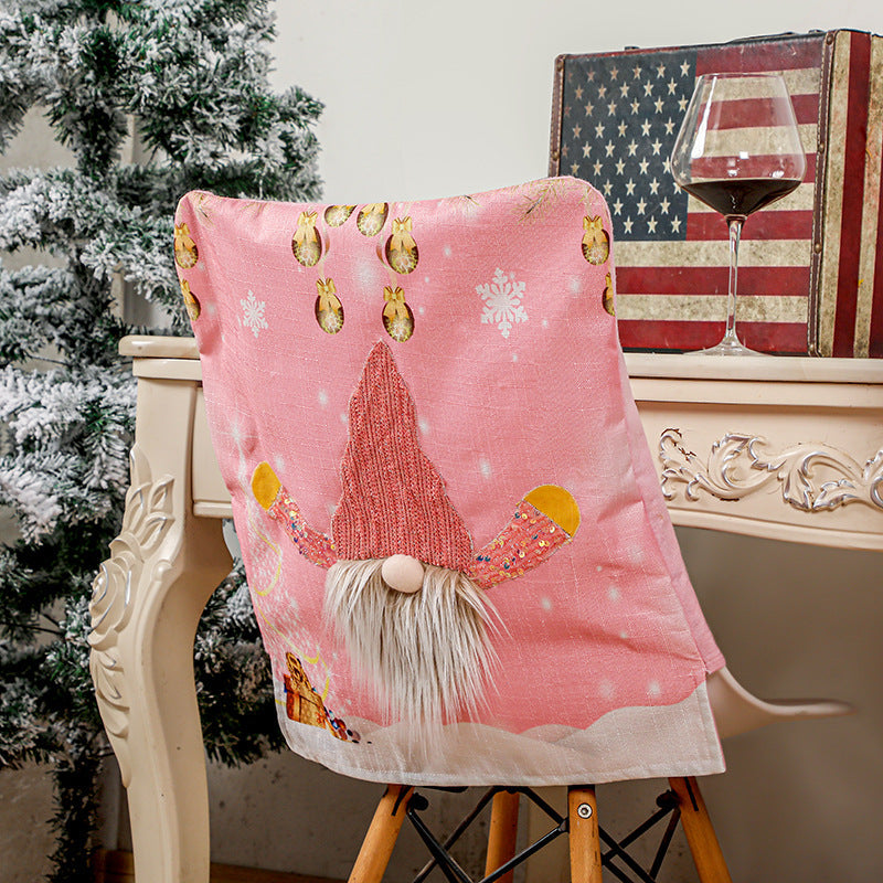 Christmas decorations chair cover with festive holiday design draped over a dining chair