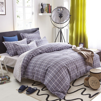 Four-piece cotton bedding set with soft home textile fabric, folded neatly on display