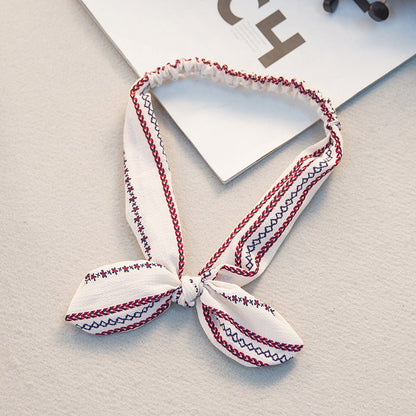 Big bow tie bunny ears headband in a playful design, close-up product view