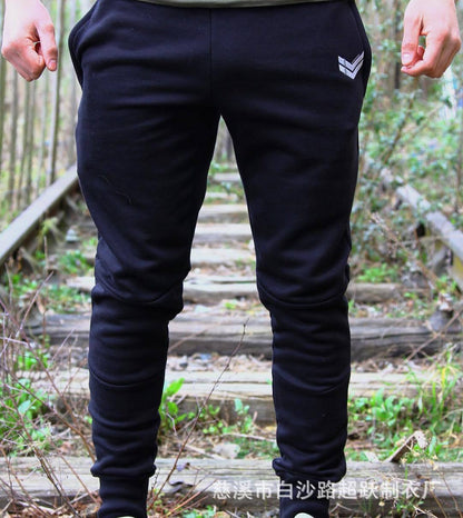 Black running training pants with elastic waistband and tapered legs, front and side view