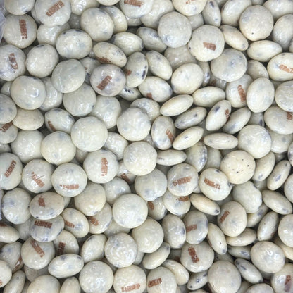 Hershey's Cookies 'N' Creme chocolate drops in a bulk Candy In Bulk bag, showing shiny white and brown candies with textured surface.