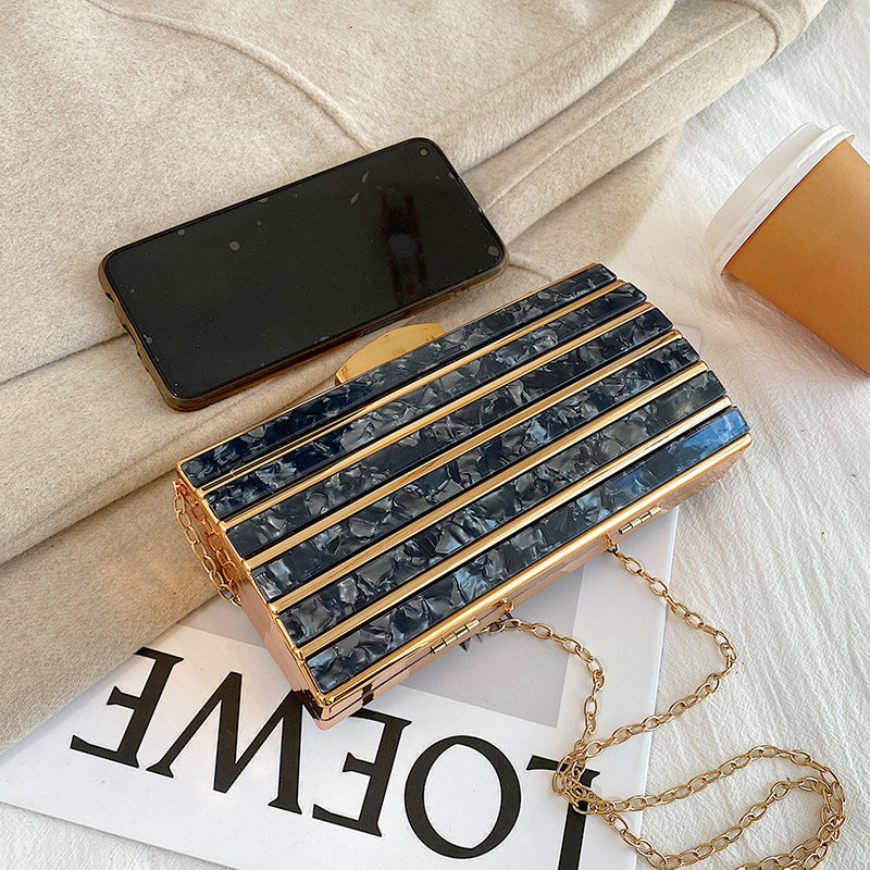 Women's high-end patch acrylic evening bag with textured design and structured silhouette.