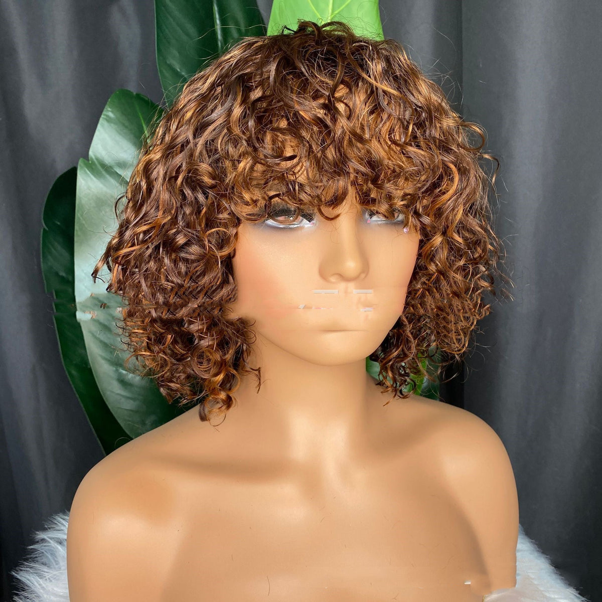 Curly human hair wig, full machine-made construction, shown on a mannequin head
