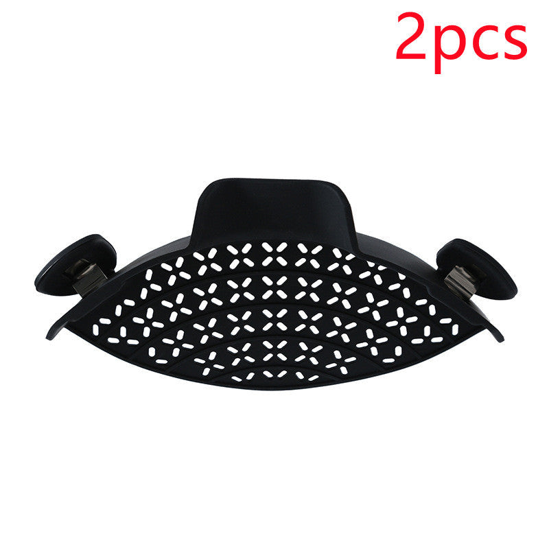 Silicone pot side drain stopper for kitchen use, shown attached to a pot rim