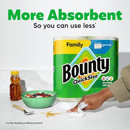 Bounty paper towels quick size white 16 family rolls, stacked on a countertop, with a roll partially unrolled for cleaning.