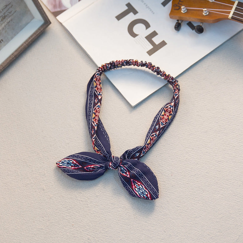 Big bow tie bunny ears headband with oversized bow and playful rabbit ears in a close-up product view