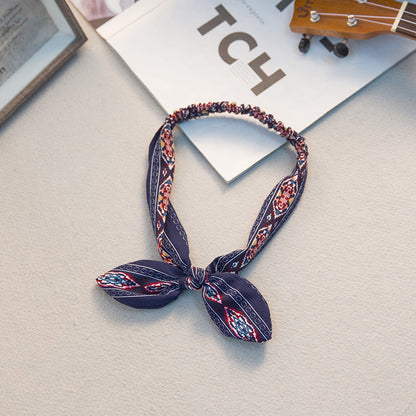 Big bow tie bunny ears headband with oversized bow and playful rabbit ears in a close-up product view