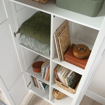 Sauder Select white storage cabinet with pantry shelves and snack chip variety inside for organized kitchen storage