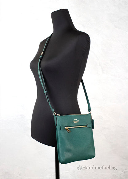 Coach Rowan Mini Dark Pine leather crossbody bag with a compact design and adjustable strap.