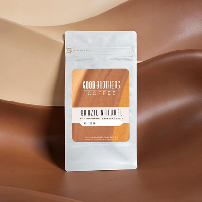 Roasted Brazil Serra Negra coffee beans by Good Brothers Coffee LLC, showing dark, glossy coffee beans on a neutral background.