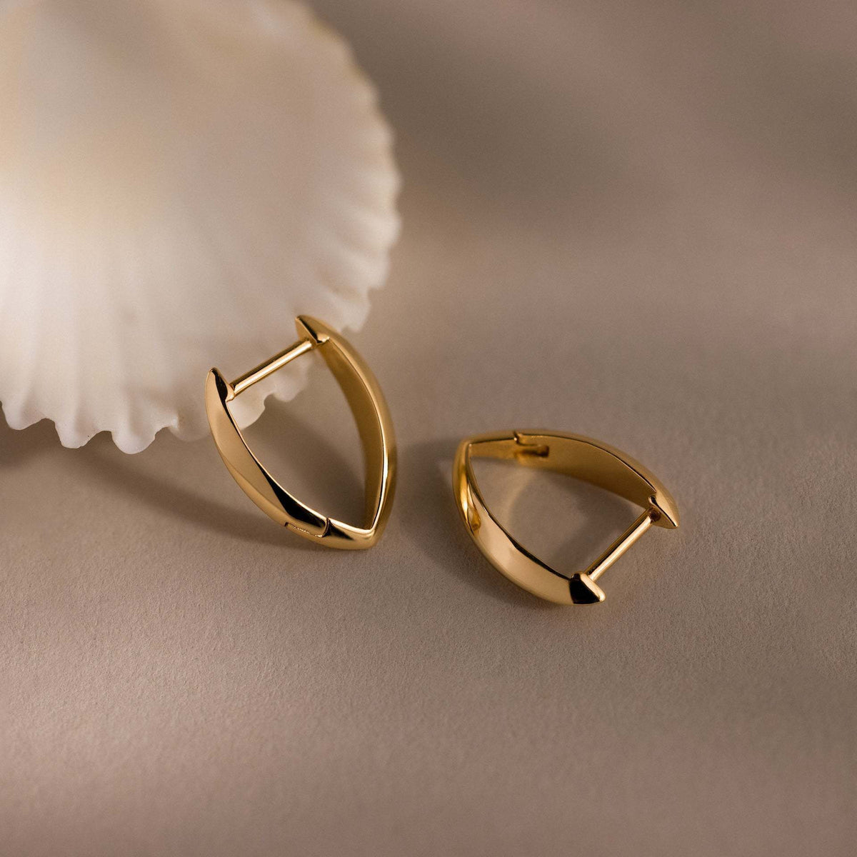 Gold-plated V-shaped earrings displayed against a plain background