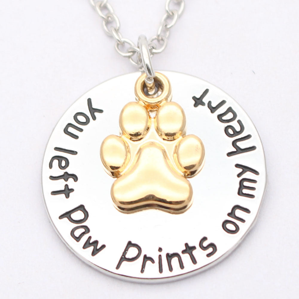 Dog paw necklace pendant on a delicate chain, close-up product view