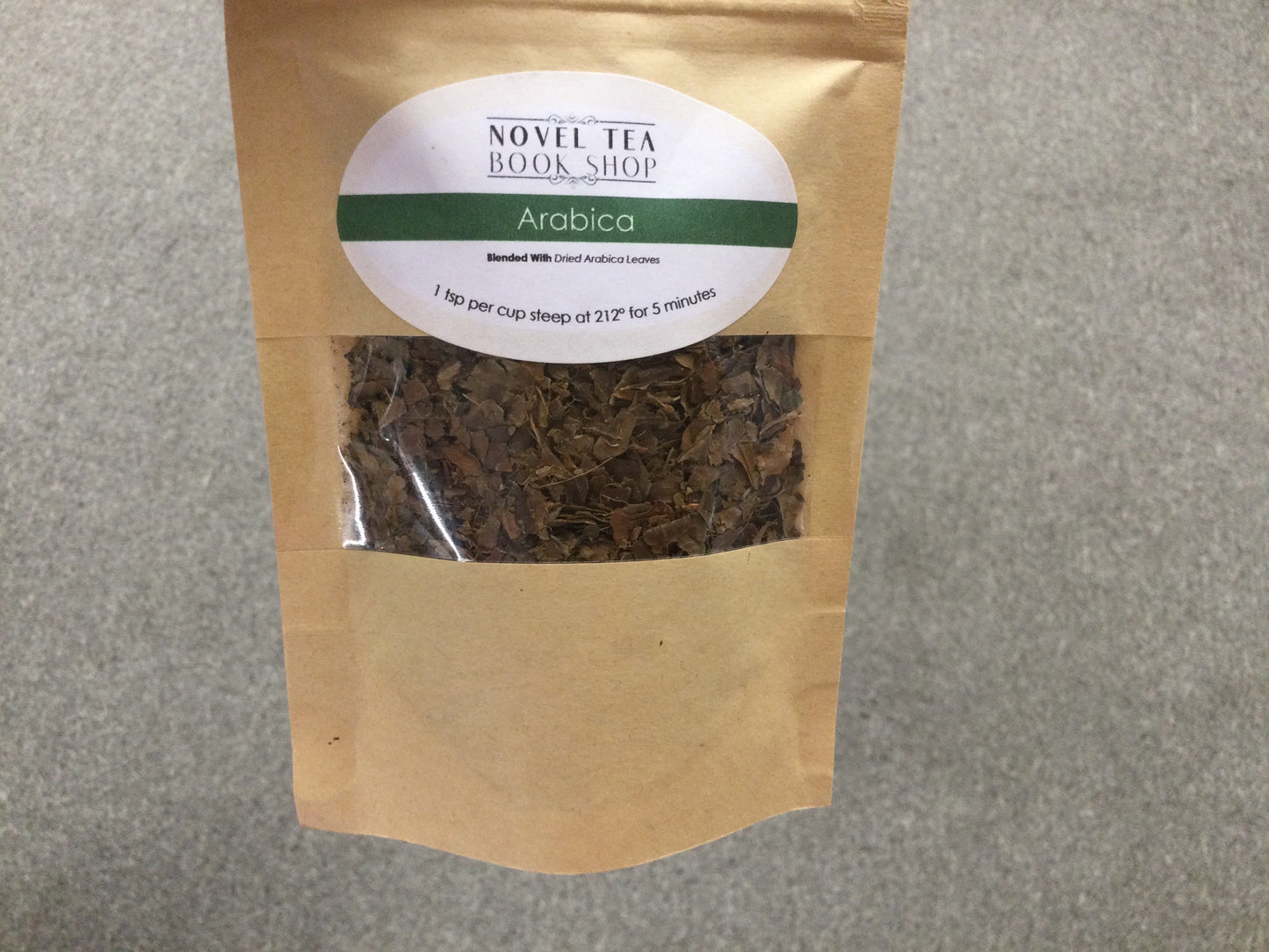 Loose leaf Arabica herbal tea in a jar, showcasing dried tea leaves from Novel Tea Book Shop.